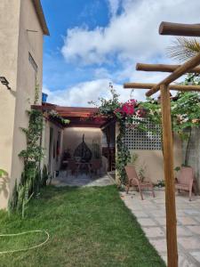 an outdoor patio with chairs and a pergola at Estúdio aconchegante com cozinha externa e quintal in Morro do Chapéu