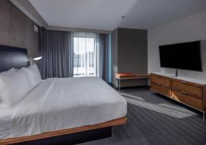 a hotel room with a bed and a flat screen tv at Courtyard by Marriott Conway in Conway