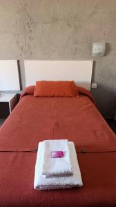 a red bed with a pink box on top of it at Hotel Cafayate Design in Cafayate