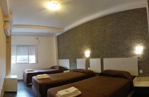 a hotel room with three beds and a window at Hotel Cafayate Design in Cafayate +21 photos