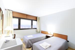 a bedroom with two beds and a window at São Roque Suites in Bragança