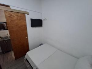 a small bedroom with a bed and a door at Hostal Machu Picchu Medellin in Medellín