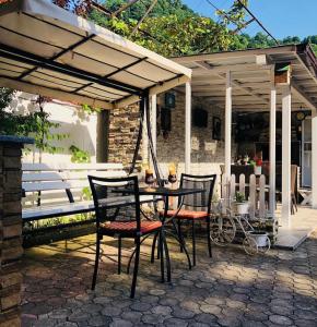 a patio with a table and chairs under a pavilion at Deluxe Family Stay Near The Beach in Kvariati