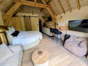 a room with a bed and a couch and a table at Domaine du Bois l'Abbé - Le Nid in Saint-Martin-Boulogne