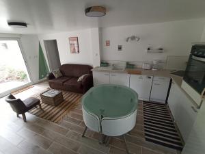 a kitchen and living room with a couch and a tub at Le nid des mésanges in Veigné