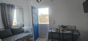 a living room with a couch and a table and a window at MaryAnn's house in Livadi