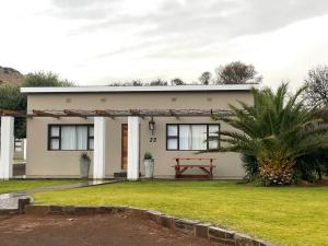 a small house with a picnic bench in front of it at Travalia Guest Farm in Nelspoort