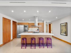 a kitchen with purple stools and a counter top at Luxury 3BR Beachfront Private Pool Ultravioleta in Cabarete