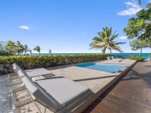 a swimming pool with lounge chairs and the beach at Luxury 3BR Beachfront Private Pool Ultravioleta in Cabarete +84 photos