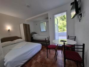a small room with a bed and a table and chairs at Canj Cozy apartment - Studio in Čanj