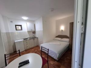 a small room with a bed and a table at Canj Cozy apartment - Studio in Čanj