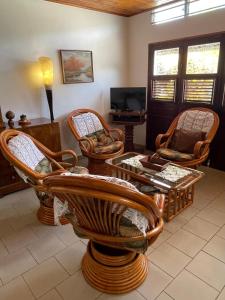 a living room with chairs and a table and a tv at CD House in Fort-de-France