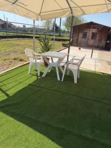 a picnic table and two chairs under an umbrella at La dolce casa in Verdellino