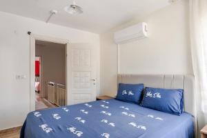 a bedroom with a blue bed with blue and white sheets at Güneş Villa in Antalya