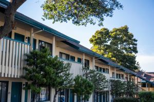 a row of apartment buildings with trees in the foreground at Scottish Fairway Inn in Monterey