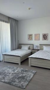 a bedroom with two beds and a rug at Home Sweet Home in Abu Dhabi