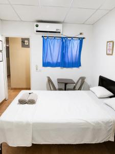 a bedroom with a large white bed with a blue curtain at Orison Managua in Managua