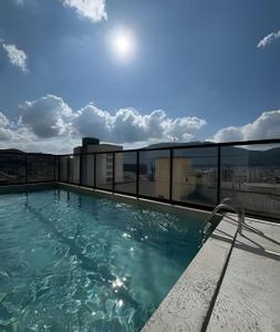 a swimming pool on the roof of a building at Suporte VIP: TOPstudio no Centro c/Piscina Jacuzzi in Poços de Caldas