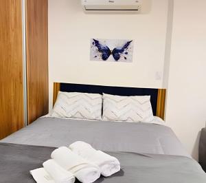 a bedroom with a bed with two towels on it at Suporte VIP: TOPstudio no Centro c/Piscina Jacuzzi in Poços de Caldas +33 photos