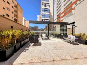 a patio in a building with benches and plants at Suporte VIP: TOPstudio no Centro c/Piscina Jacuzzi in Poços de Caldas