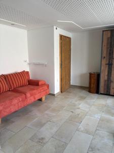 a living room with a red couch and a tile floor at FeWo Johann Friedrich in Hilpoltstein +2 photos