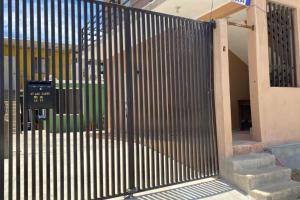 a metal gate in front of a building with stairs at Casa Cangrejos in Cabo San Lucas