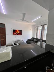 a living room with a couch and a tv on the wall at Blossom Homes A2 in Mombasa