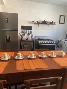a kitchen with a wooden table with cups on it at Casa Cangrejos in Cabo San Lucas