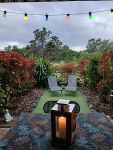 a patio with two chairs and a table with a candle at Ghiso'Lodge in Ghisonaccia