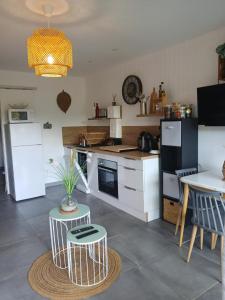 a kitchen with white appliances and a table with chairs at Ghiso'Lodge in Ghisonaccia