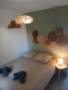 a bedroom with a large white bed with hats on the wall at Ghiso'Lodge in Ghisonaccia