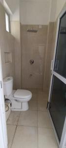 a bathroom with a toilet and a glass shower at Blossom Homes A2 in Mombasa +11 photos