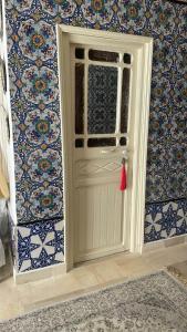 a white door in a room with blue tiles at Beit Khalifa in Kairouan