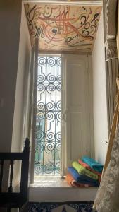 a window in a room with a door and some blankets at Beit Khalifa in Kairouan +1 photo