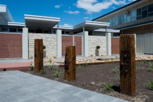 two wooden posts in front of a building at Loxton Courthouse Apartments in Loxton