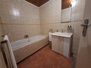 a bathroom with a bath tub and a sink at Le Cape Nest Guest House in Parow