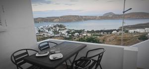 a table and chairs on a balcony with a view at MaryAnn's house in Livadi