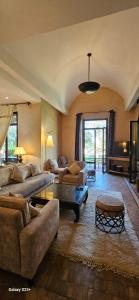 a large living room with couches and a table at Belle villa avec piscine privée in Ala el Ma +23 photos