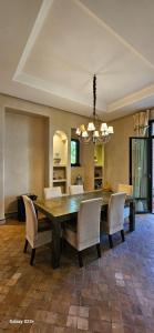 a dining room with a table and chairs at Belle villa avec piscine privée in Ala el Ma