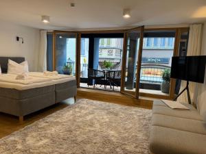a bedroom with a bed and a tv and a couch at AltstadtOase in Konstanz