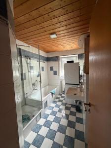 a bathroom with a shower and a sink and a tub at Eltons Fewo beim EuropaPark 4- Zimmer Apartment in Herbolzheim