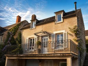 an old house with a balcony on top of it at Au Morvan Voyageur in Asquins