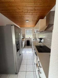a kitchen with stainless steel appliances and a wooden ceiling at Eltons Fewo beim EuropaPark 4- Zimmer Apartment in Herbolzheim