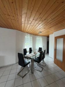 a dining room with a table and black chairs at Eltons Fewo beim EuropaPark 4- Zimmer Apartment in Herbolzheim +6 photos