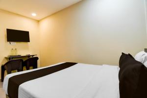 a hotel room with a bed and a television at Hotel O Premium 12th Night in kolkata