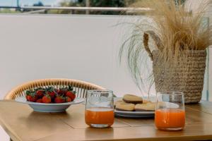a table with a plate of food and a bowl of fruit at Pillow Apartments in Nikiana