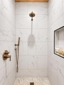 a bathroom with a shower with white marble walls at Sommer House Inn-Aloha Room in Jasper