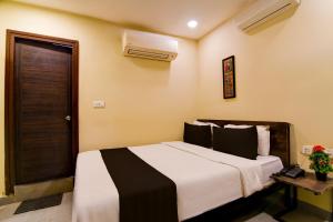 a bedroom with a large bed with a black and white blanket at Hotel O Premium 12th Night in kolkata