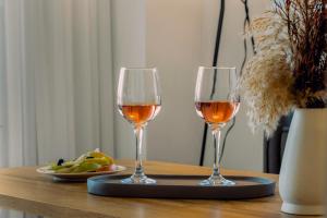 two glasses of wine on a table with a plate of fruit at Pillow Apartments in Nikiana +37 photos