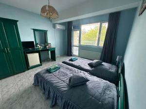 a bedroom with two beds and a desk in it at Villa Nora in Albena